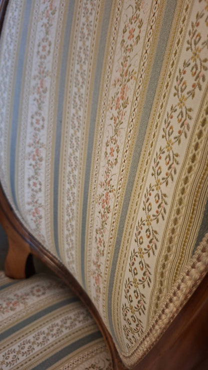 Detail des hellblau-cremefarbenen floralen Streifenbezugs am antiken Sessel