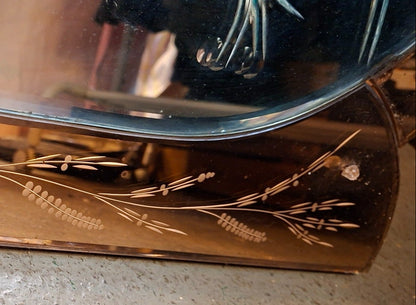 Detail des roséfarbenen Spiegelglas-Sockels mit floraler Gravur