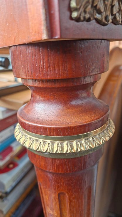 Gedrehtes Tischbein aus rotbraunem Holz mit goldfarbenem Zierring