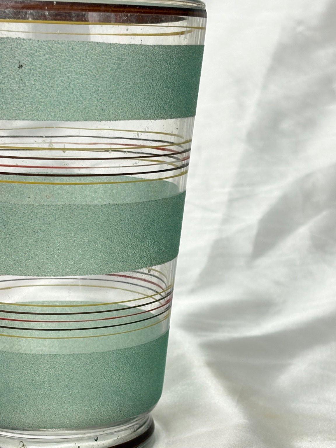 Detail der mintgrünen Glasvase mit farbigem Liniendekor